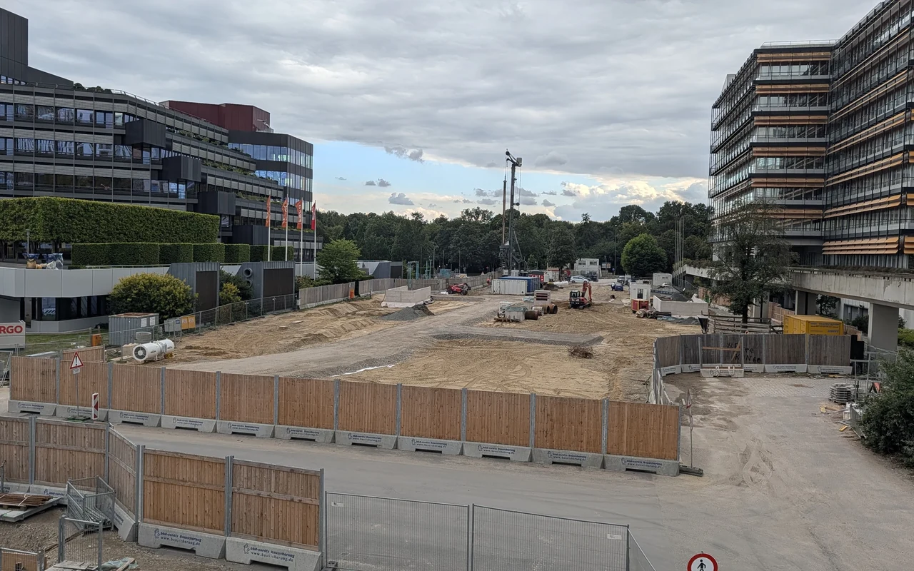 Construction area at Hamburg’s U5 City Nord station, between office buildings, with materials and a crane.