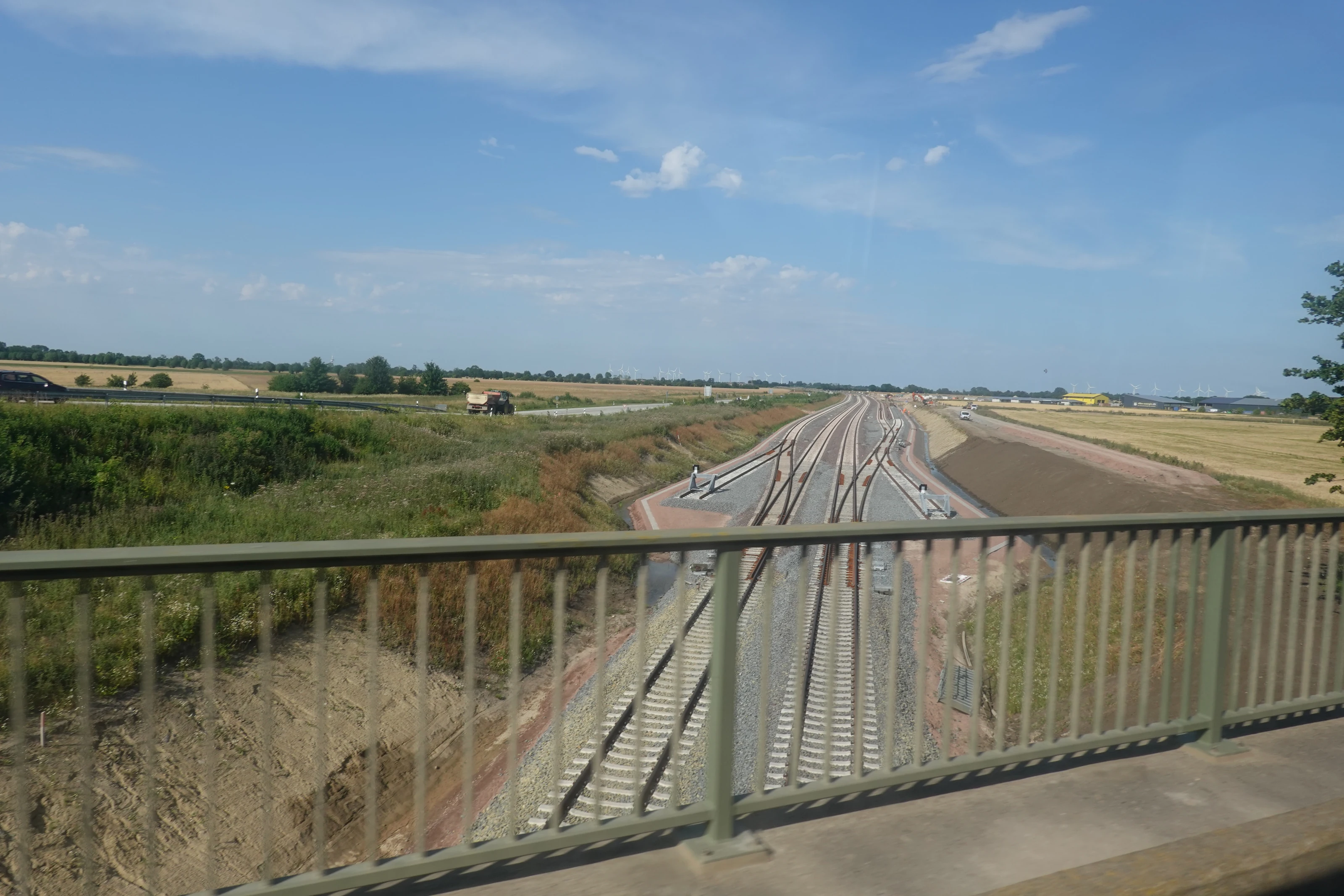 New railway tracks near Burg auf Fehmarn, seen from a bridge with its railing in the foreground.
