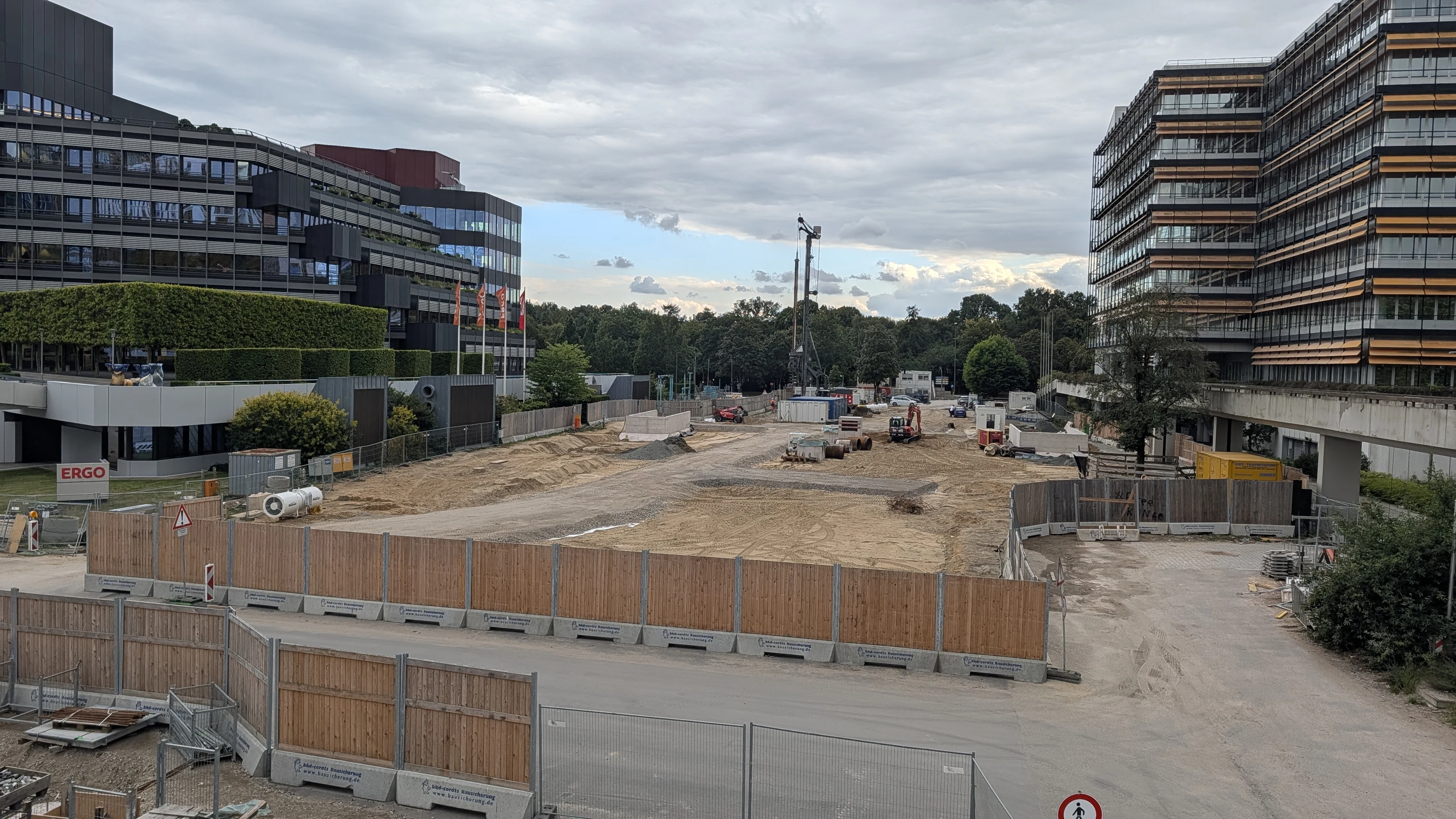 Construction area at Hamburg’s U5 City Nord station, between office buildings, with materials and a crane.
